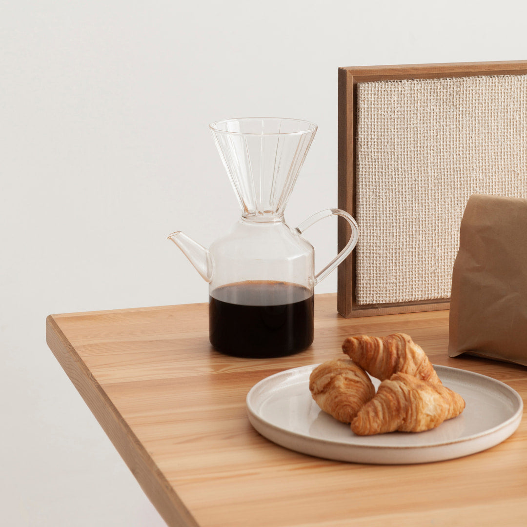 Lupinenkaffee in Kanne neben Croissants