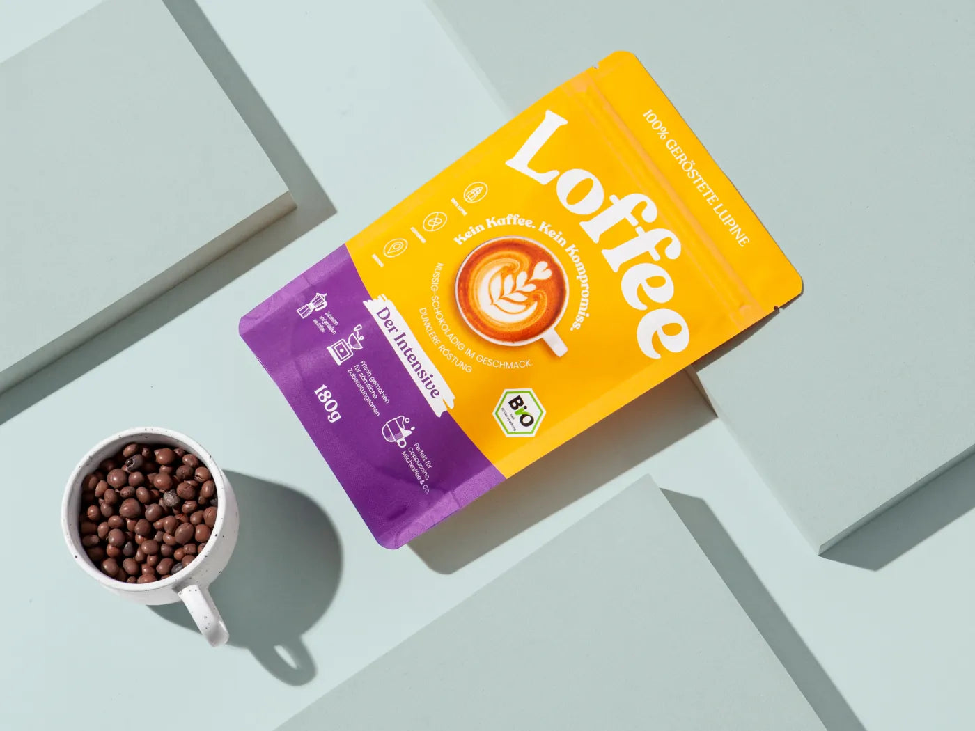 Lupinenkaffee-Tüte von oben, daneben Tasse mit ganzen Lupinen darin